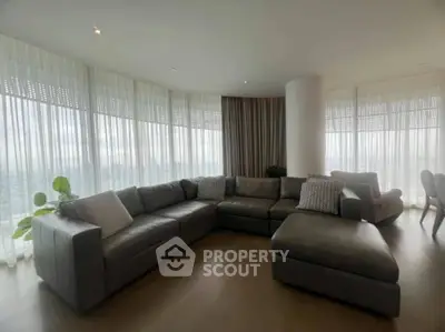 Spacious modern living room with panoramic windows and stylish sectional sofa