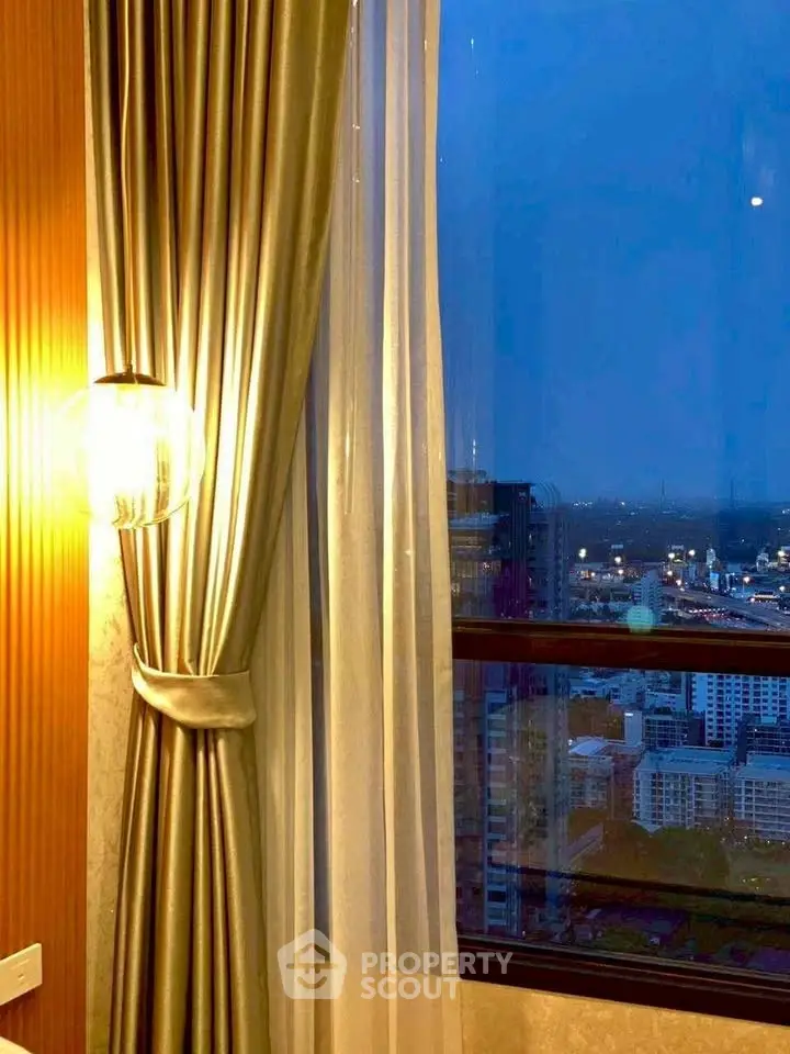 Luxurious high-rise apartment with stunning city view and elegant curtains.