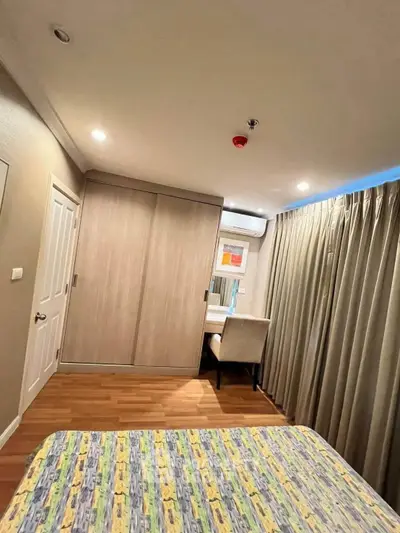 Cozy bedroom with modern decor, featuring a comfortable bed, stylish wardrobe, and a work desk by the window.
