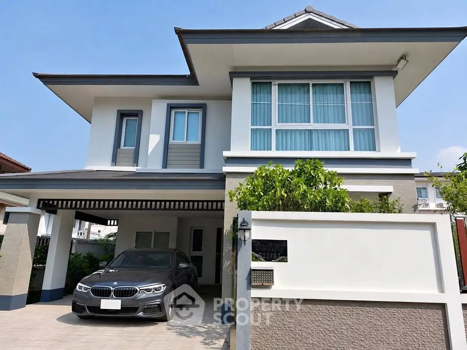 Modern two-story house with sleek design and attached garage in a suburban neighborhood.
