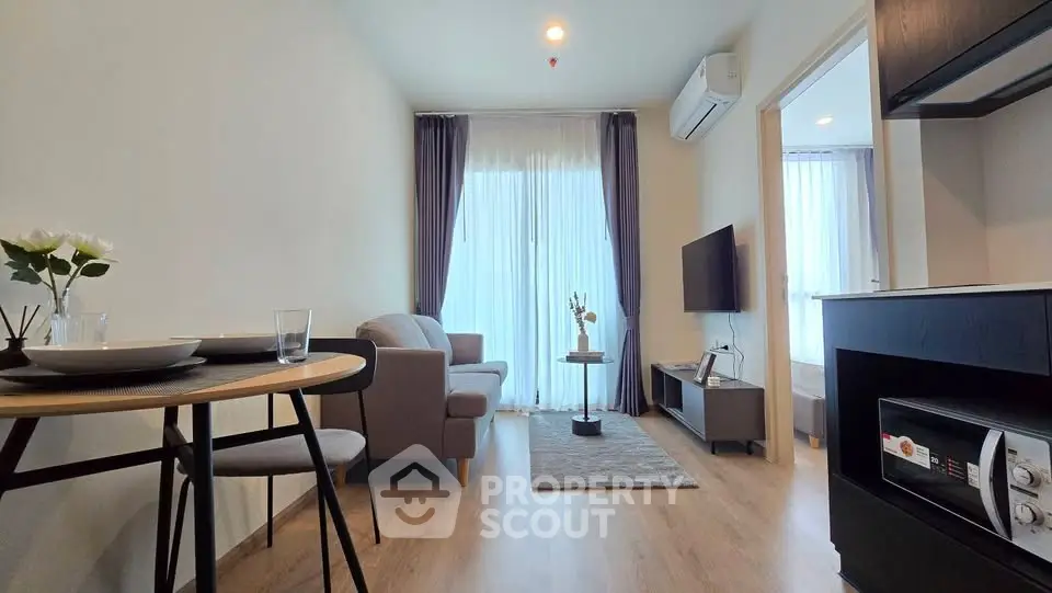 Modern living room with cozy furniture and open kitchen layout in a stylish apartment.