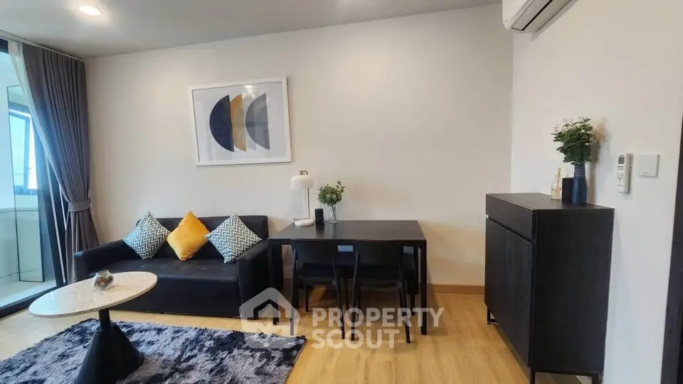 Modern living room with stylish decor and natural light, featuring a cozy sofa and dining area.