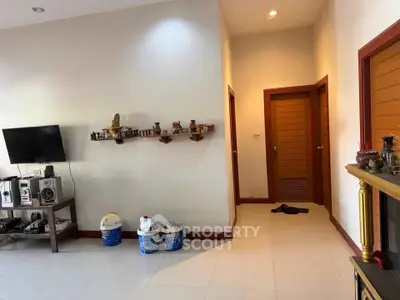Spacious living room with modern decor and wall-mounted TV, perfect for relaxation and entertainment.