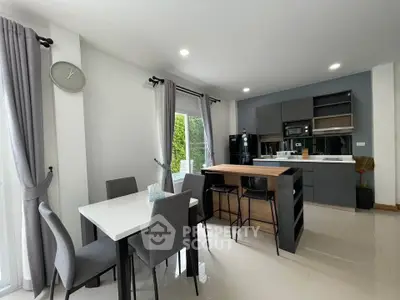 Modern kitchen and dining area with sleek design and natural light