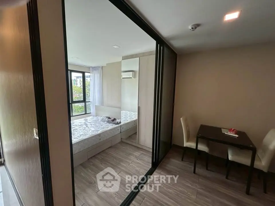 Modern bedroom with large windows and dining area in a stylish apartment.