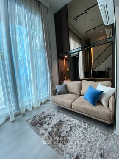 Luxurious living room with high ceilings and floor-to-ceiling windows in modern apartment.