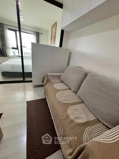 Cozy bedroom with modern decor and comfortable sofa in a stylish apartment.