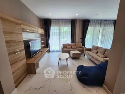 Spacious modern living room with elegant furniture and large windows for natural light.