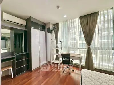 Spacious bedroom with modern furniture and large windows in a high-rise apartment.