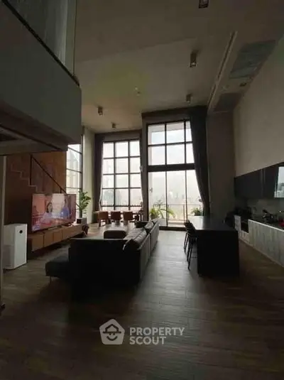 Spacious modern living room with high ceilings and large windows offering natural light.