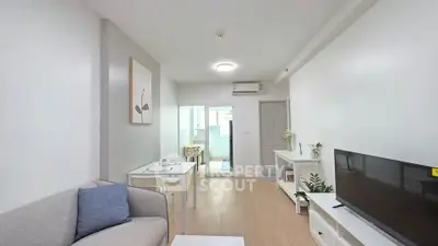 Modern living room with sleek furniture and natural light, featuring a cozy dining area and stylish decor.