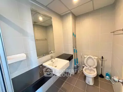 Modern bathroom with sleek fixtures and neutral tiles, featuring a spacious layout and contemporary design.