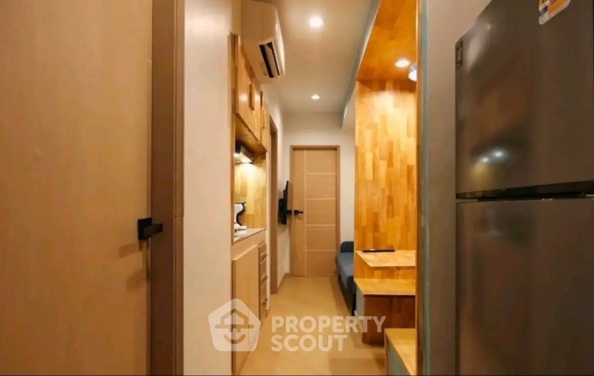 Modern compact kitchen with sleek appliances and cozy dining area in stylish apartment.