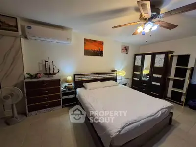 Spacious bedroom with modern furnishings and ceiling fan, perfect for comfort and relaxation.