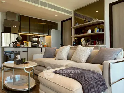 Modern living room with cozy sofa and stylish kitchen in open layout apartment.