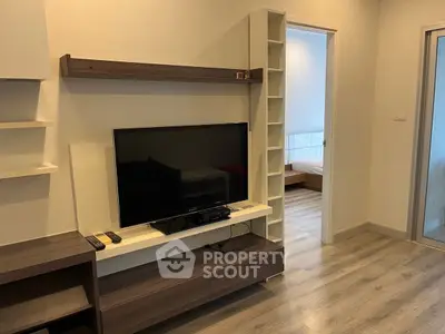 Modern living room with sleek TV stand and open doorway to bedroom