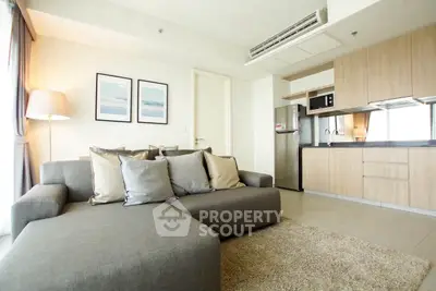 Modern living room with cozy sofa and stylish kitchen in open layout apartment.