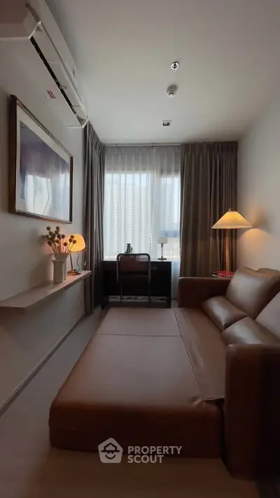 Cozy living room with modern decor and natural light, featuring a leather sofa and stylish lighting.
