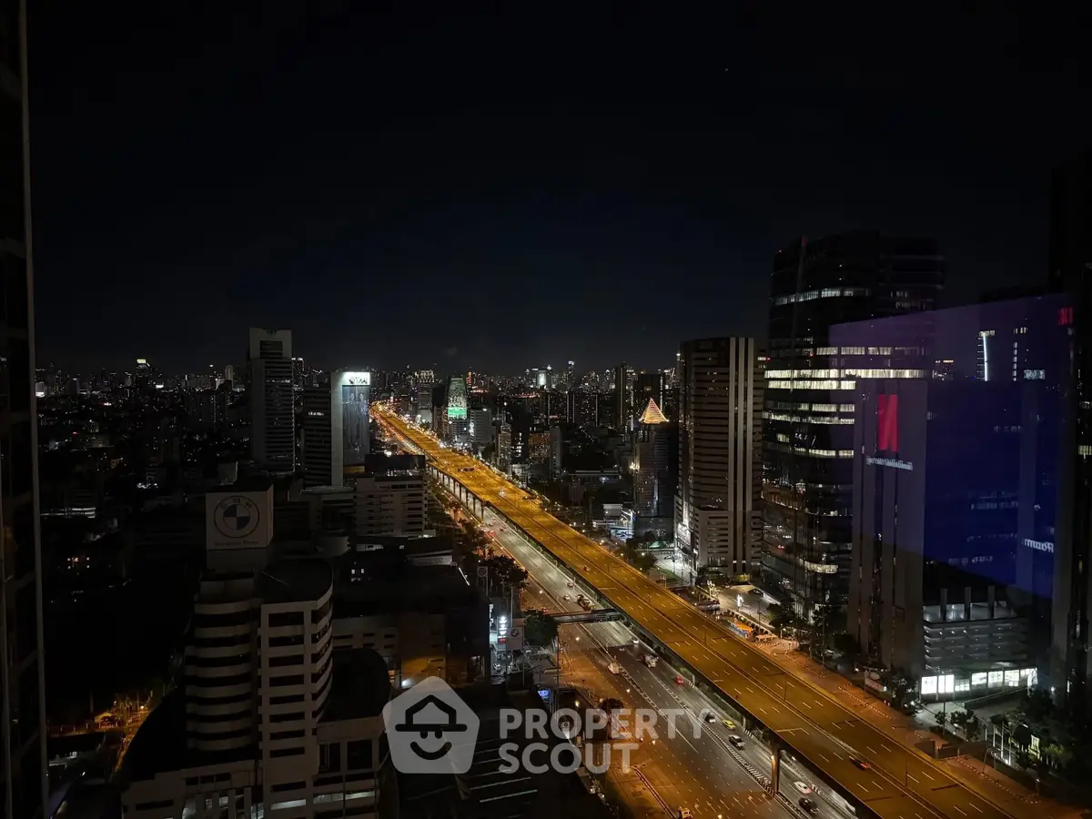 Stunning night cityscape view from high-rise building with illuminated streets and skyline.