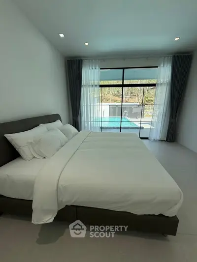 Luxurious bedroom with pool view, featuring elegant curtains and modern decor, perfect for relaxation.