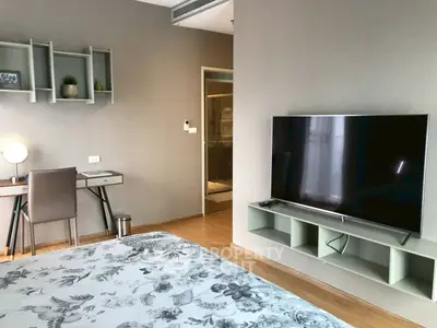 Modern bedroom with large TV and stylish workspace