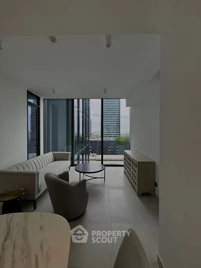 Modern living room with floor-to-ceiling windows offering stunning city views, featuring sleek furniture and minimalist design.