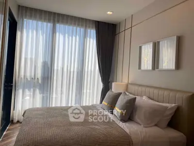 Luxurious bedroom with elegant decor and large windows offering abundant natural light.