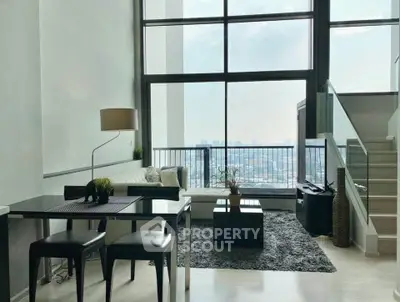 Modern living room with high ceilings and stunning city view, featuring sleek furniture and a cozy atmosphere.