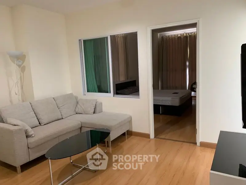 Modern living room with cozy sofa and view into bedroom, perfect for urban living.