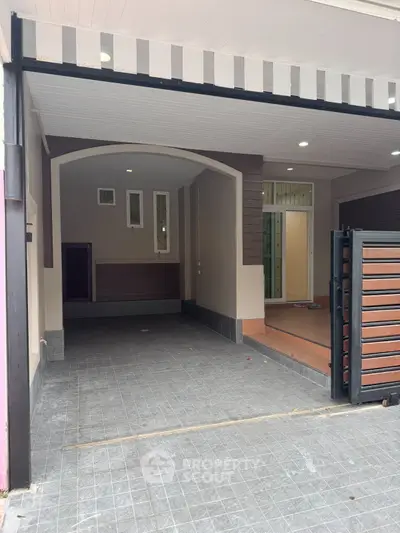 Modern residential entrance with covered parking and sleek design