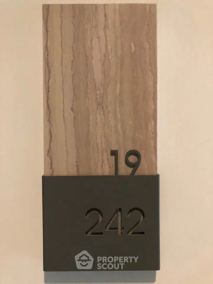Modern apartment number plaque with stylish design, showcasing unit 242 in building 19.