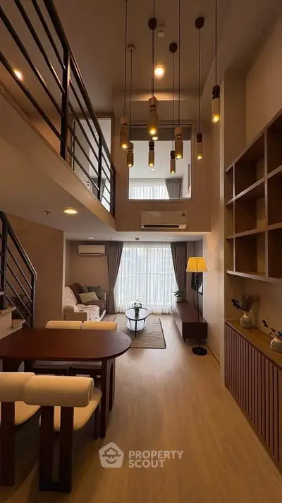 Stunning modern living room with high ceilings and elegant lighting in a duplex apartment.