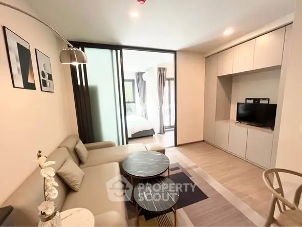 Modern living room with stylish decor and open layout leading to a bedroom, perfect for urban living.