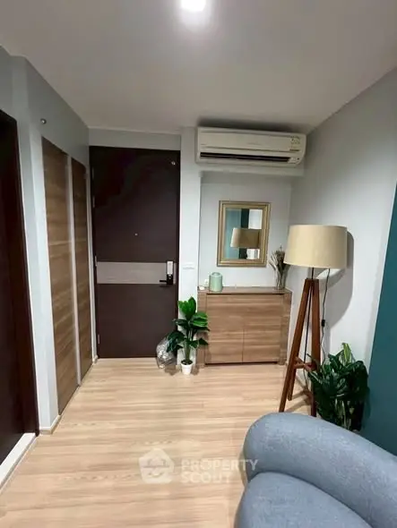 Modern living room with stylish decor and air conditioning, featuring wooden flooring and elegant furniture.