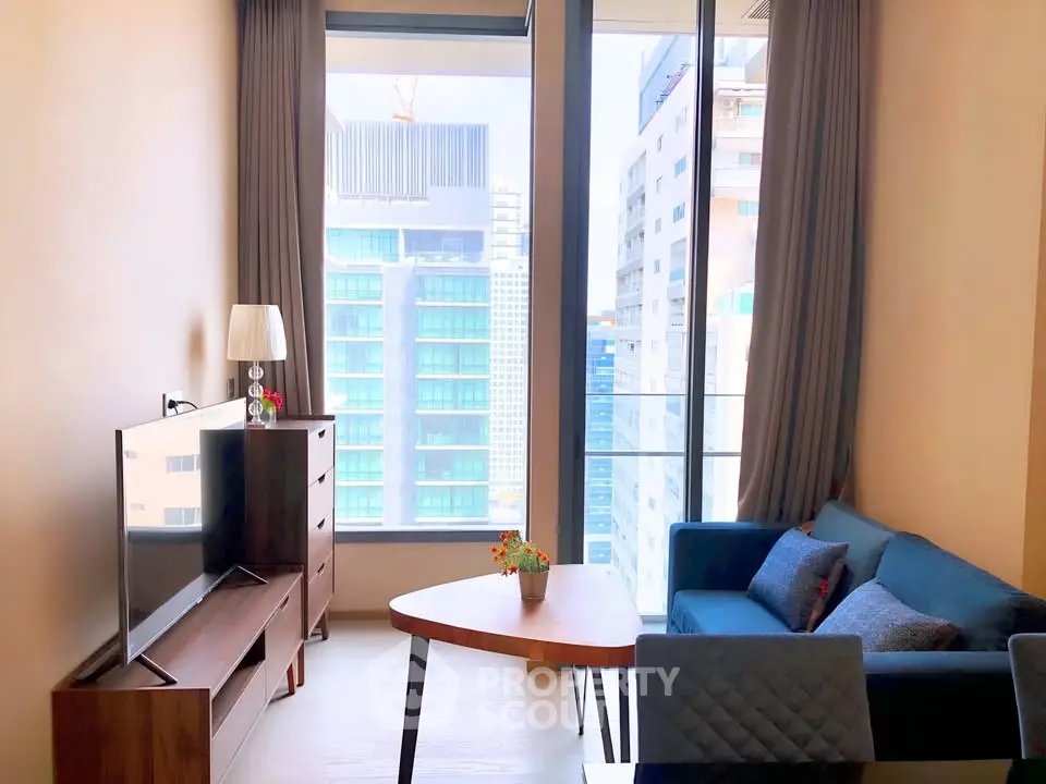 Modern living room with large windows and city view, featuring stylish furniture and natural light.