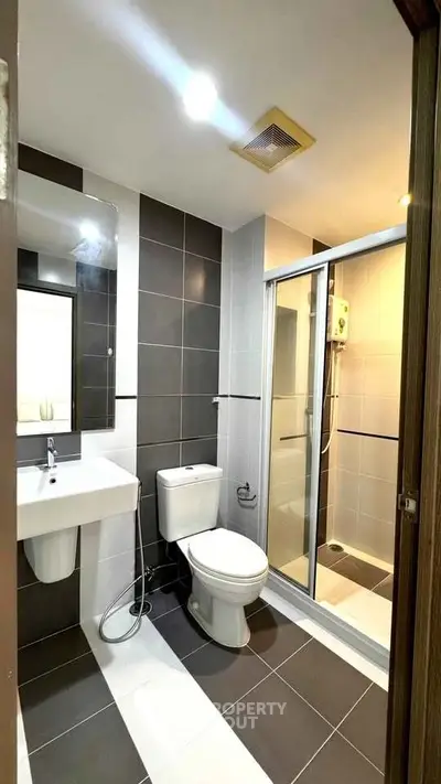 Modern bathroom with sleek design, featuring a glass shower enclosure and stylish fixtures.