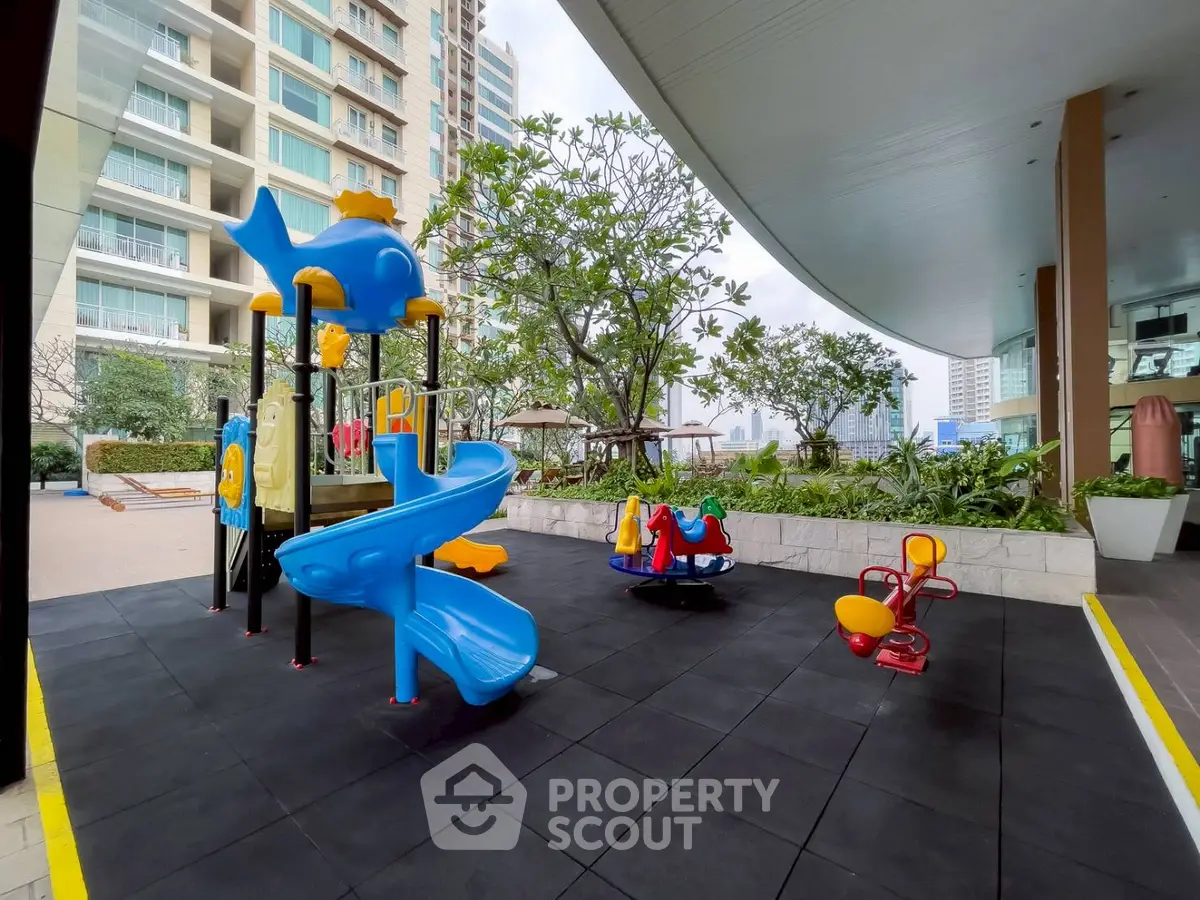 Modern residential building with vibrant children's playground and lush greenery.