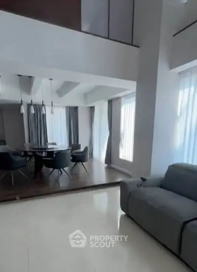 Spacious modern living room with elegant dining area and large windows