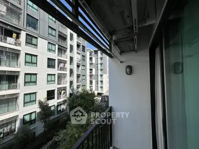 Modern apartment balcony with city view and greenery