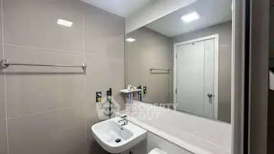 Modern bathroom with sleek fixtures and large mirror in a contemporary apartment.