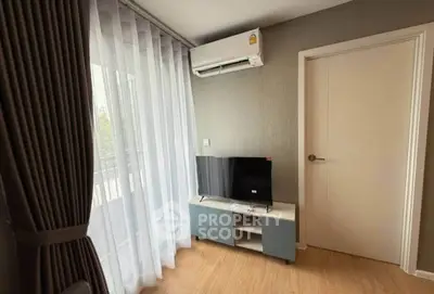 Modern living room with sleek TV stand and air conditioning, featuring elegant curtains and wooden flooring.