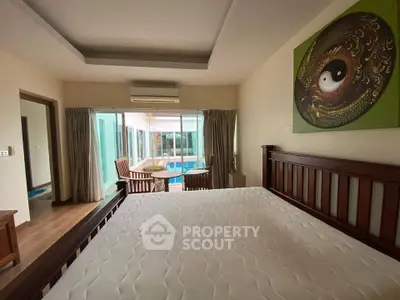 Spacious bedroom with pool view and stylish decor in modern home