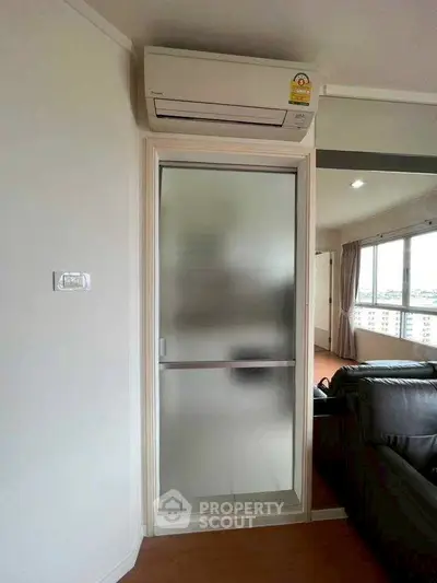 Modern living room with air conditioning and frosted glass door, offering a cozy and comfortable atmosphere.