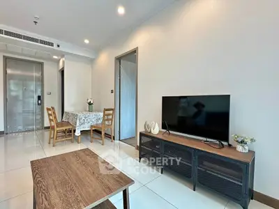Modern living room with sleek furniture and dining area in open layout apartment.