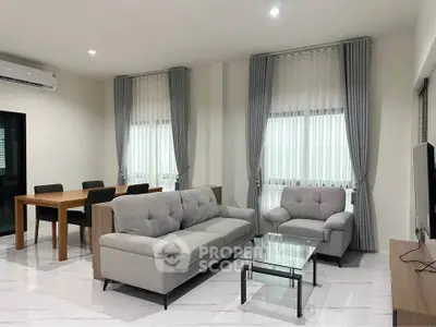 Modern living room with elegant gray furniture and dining area