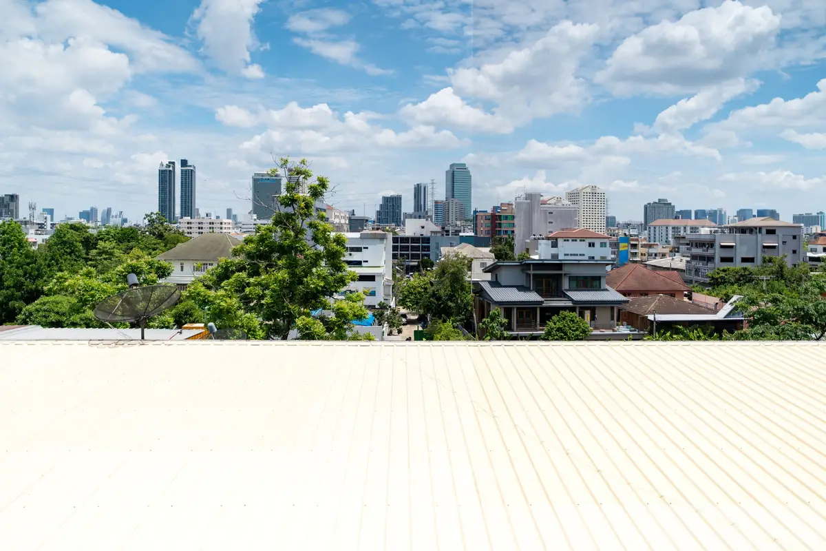 Stunning cityscape view from a rooftop with lush greenery and skyline in the background.