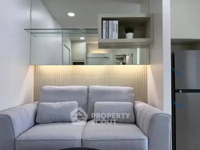 Modern living room with stylish grey sofa and sleek shelving, perfect for urban living.