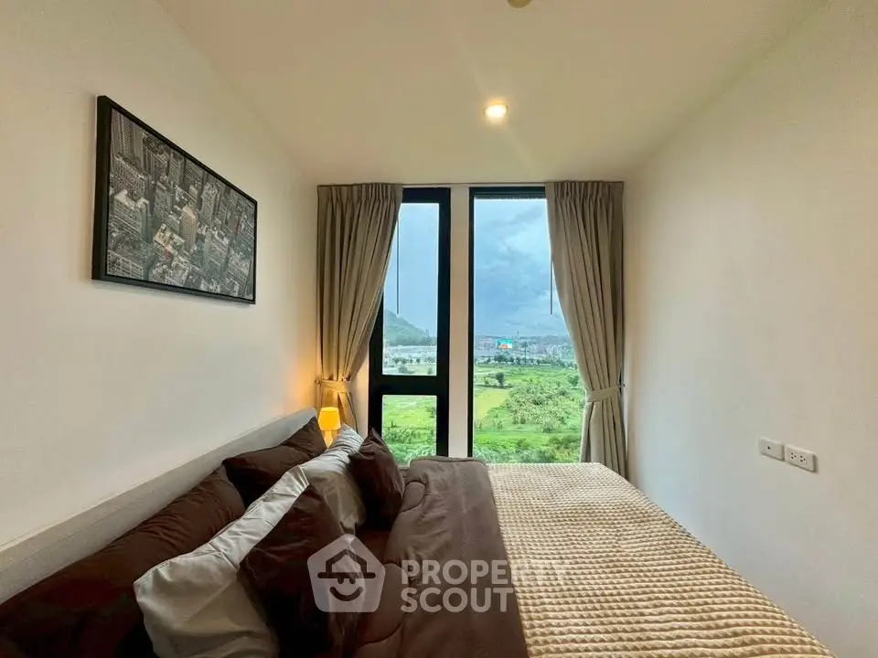 Cozy bedroom with scenic view and modern decor in a high-rise apartment.