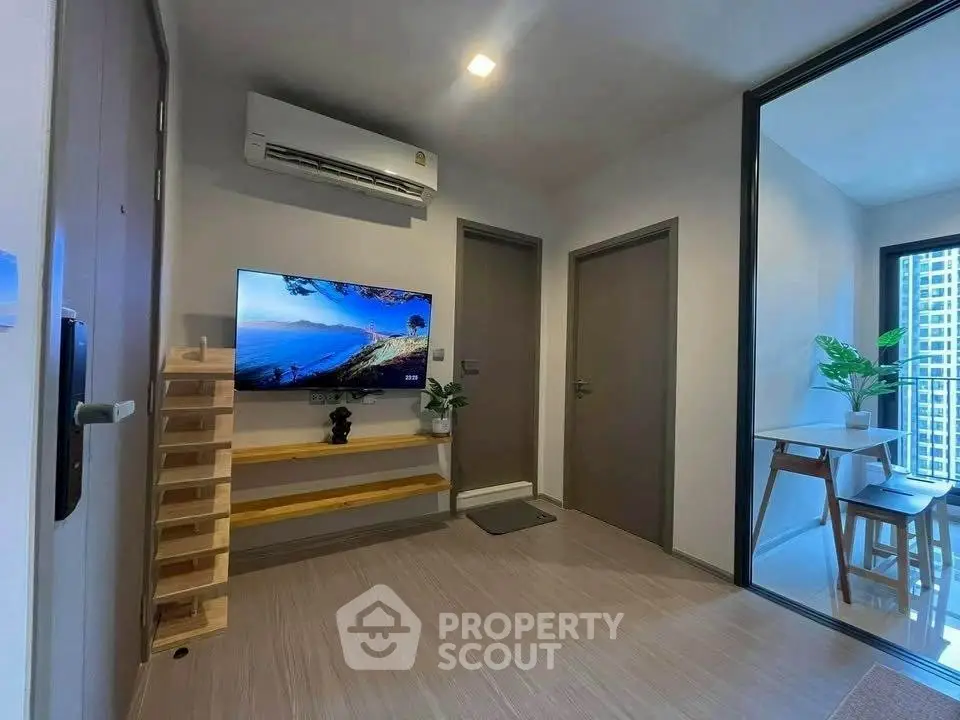 Modern living room with air conditioning and TV, adjacent to a stylish dining area with balcony view.