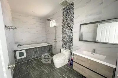 Spacious modern bathroom with elegant tile design and luxurious bathtub.